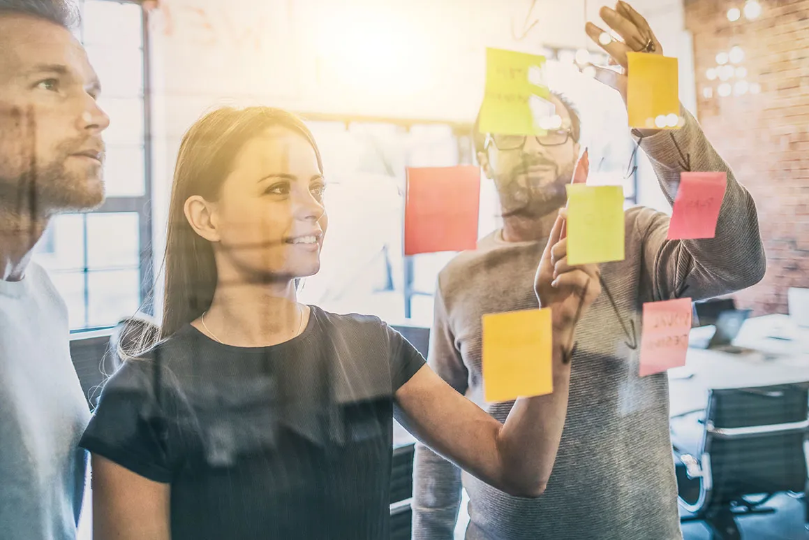 Team planning with sticky notes on a glass wall